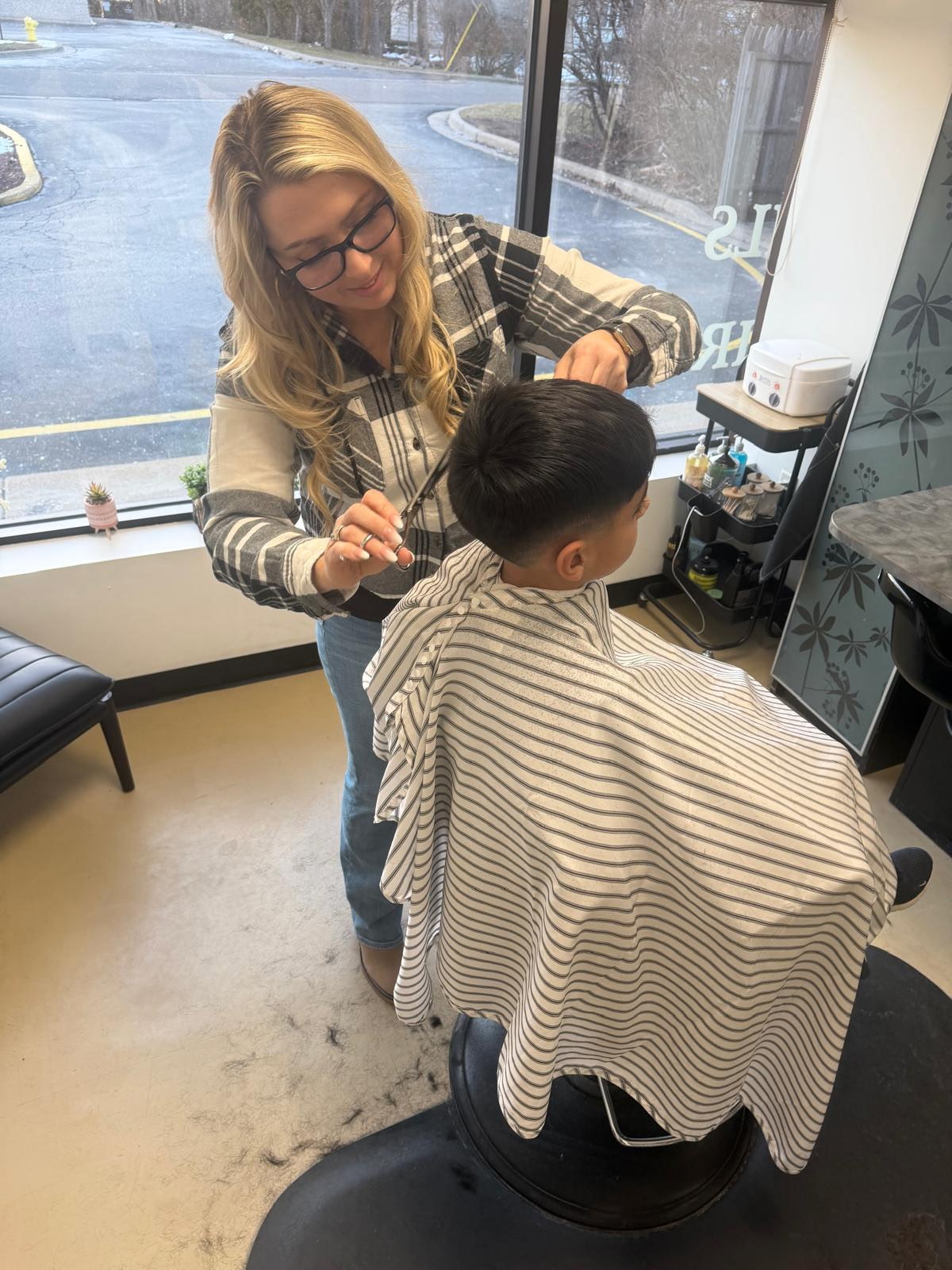 Stylist cutting a client's hair inside the salon